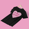 Funny and bold black t-shirt for Latina women with the phrase 'be kind chingona', with the word 'kind' crossed out, in a pink heart graphic and old-English style lettering