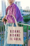 A funny spanish canvas tote bag for latinos with the words 'Besame. Besame El Culo' in deep purple vintage lettering