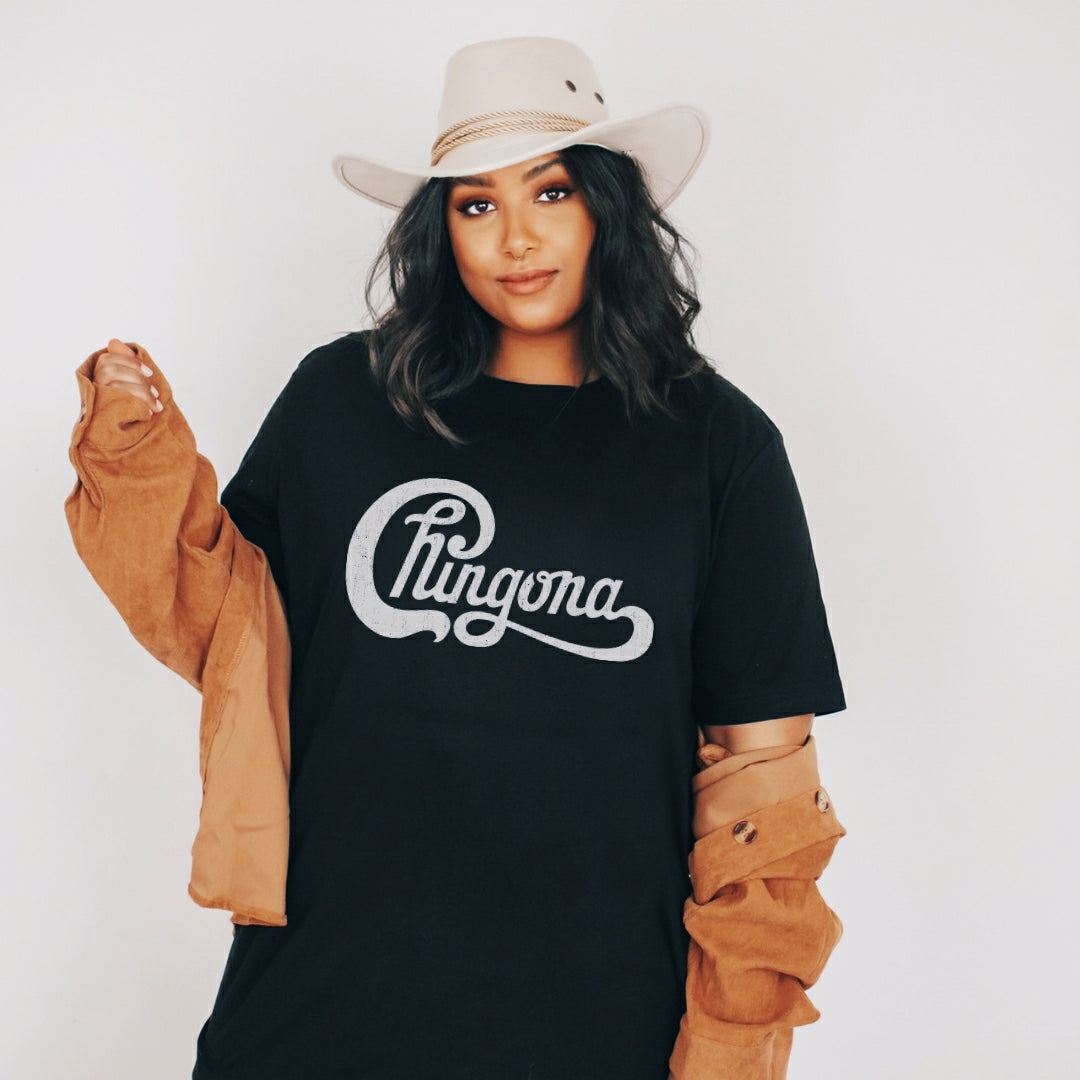Mexican woman wearing a Funny and empowering black t-shirt for Latinas, featuring the word 'Chingona' in a parody of a famous rock-band logo