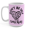 Pink and white tall mug with a heart-shaped concha pan dulce, mug says "DON’T BE SELF-CONCHAS"