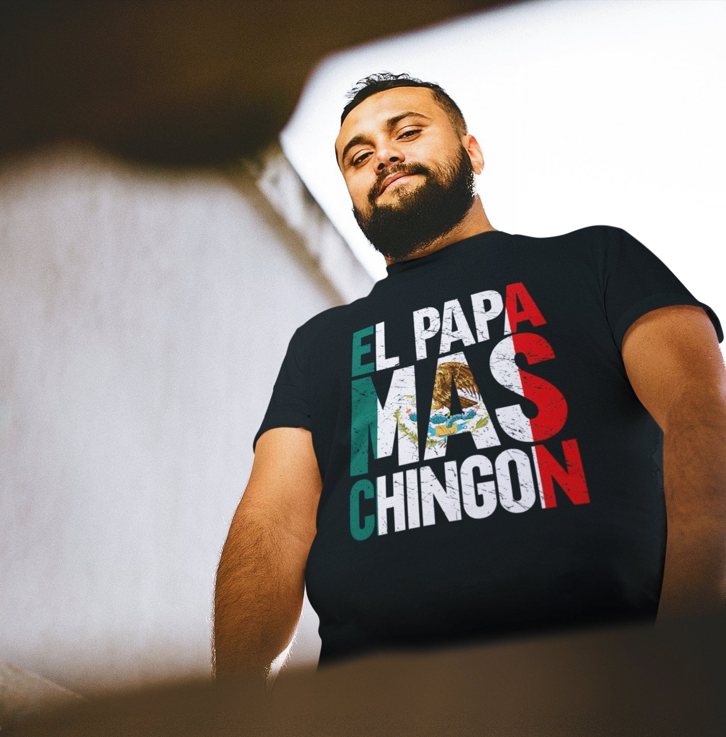 mexican man wearing an empowering black t-shirt for men with a graphic of the Mexican flag and the words "El Papa Mas Chingon