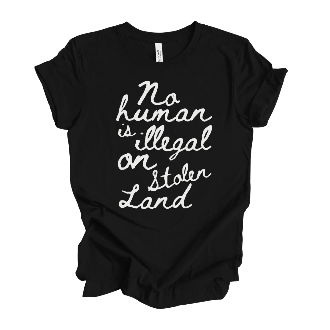 "Feminine 'No human is illegal on stolen land' T-Shirt in white handwritten text on black