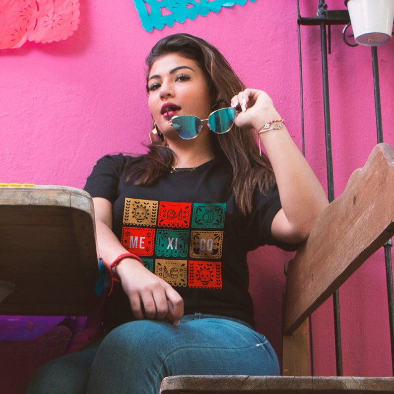 mexican woman wearing a Unique black t-shirt with a bold papel picado graphic and 'Mexico' text celebrating Mexican culture