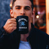 Photo of a man holding a black ceramic mug with green agave plant graphic and white text "probably tequila"