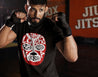 Hispanic man in a boxing pose wearing a Funny and empowering black t-shirt for Spanish speakers. the graphic is tattoo-style lucha Libra mask. the text on the mask states "sin lucha, no hay Victoria"