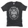 dark heather gray T-shirt featuring a tattoo-style Mexican sugar skull design with text "taco tinted dreams" and "nuestra cultura, nuestro corazón