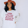 Mexican woman wearing a funny white t-shirt that states "I wish I was full of tacos instead of emotions" in vintage red lettering.